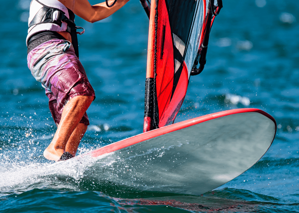 A man in bathing suit wind surfing in ocean